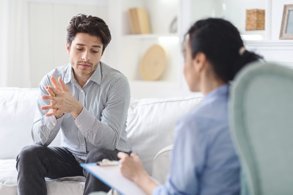 Individual discussing options for professional help with a therapist, emphasizing the importance of seeking support.