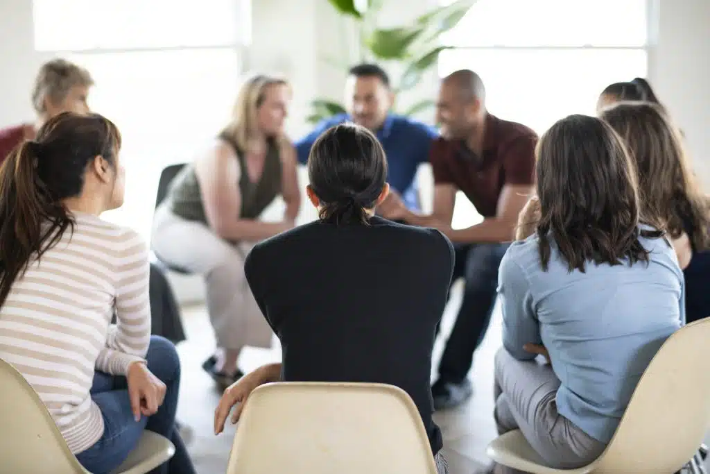 Illustration of a support group session, showing individuals sharing experiences and offering mutual support in a group setting.