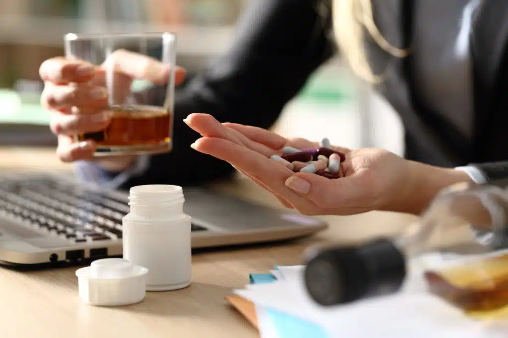 A person exploring various treatment options for addiction at a desk with books and a laptop