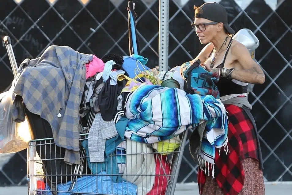 Former model Loni Willison sitting outdoors, highlighting her journey from modeling fame to homelessness due to mental health struggles and addiction.