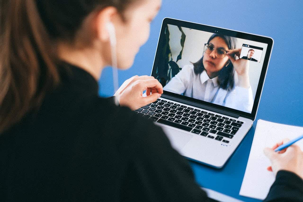 Person participating in an online therapy session via video call on a laptop.