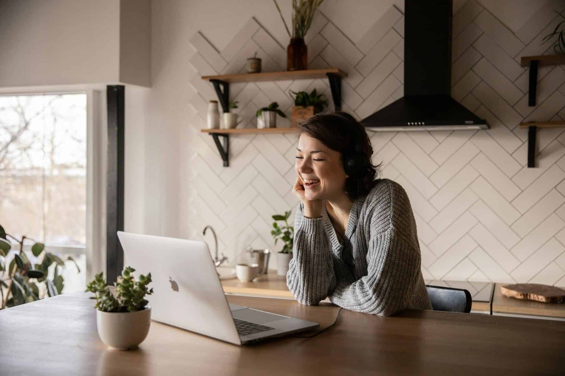 a woman sitting at a table with a laptop