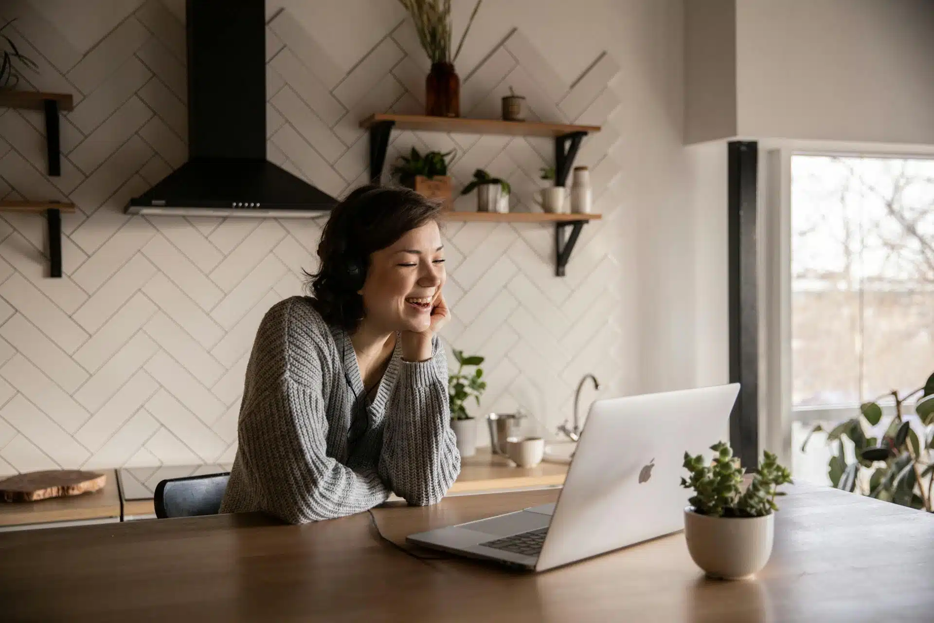a woman sitting at a table with a laptop
