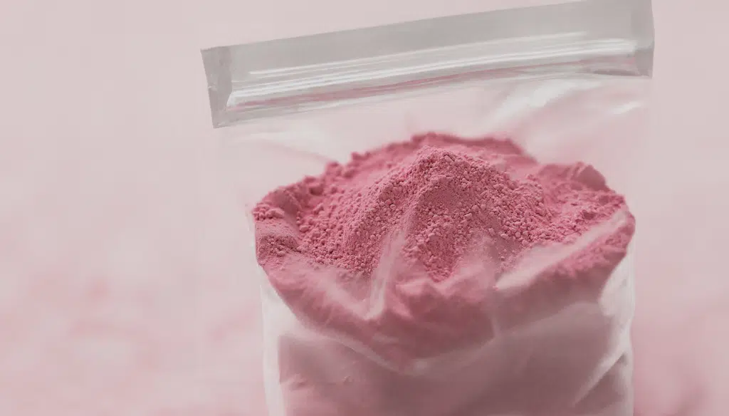 Close-up of pink cocaine powder on a dark surface, often used at parties and containing dangerous synthetic substances