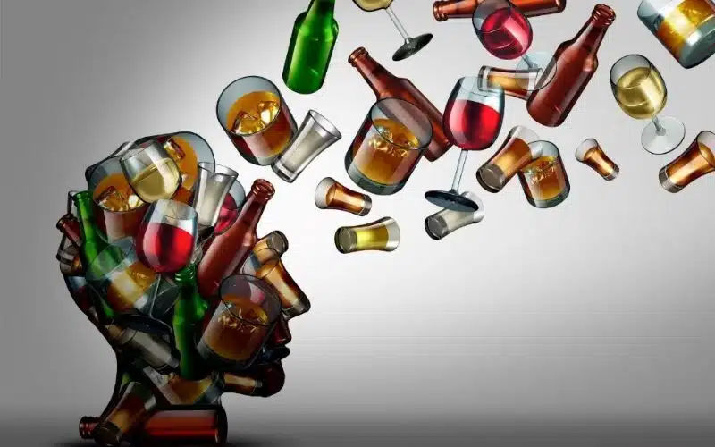 Person sitting alone with an empty alcohol bottle, symbolizing the struggle with alcohol addiction.