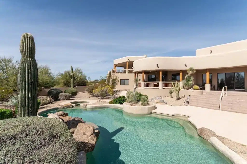 Outdoor swimming pool at Cornerstone Healing Center in Scottsdale, AZ 85260 surrounded by palm trees and lounge chairs