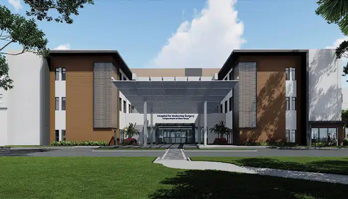 Main entrance of Memorial Hospital of Tampa in Tampa, Florida, with patients and staff coming through glass automatic doors under &lsquo;Memorial&rsquo; signage.