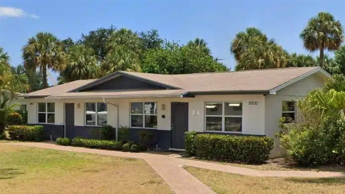 Residential-style recovery campus with palm trees at Sunset House Recovery Center, 8800 Sunset Drive, Palm Beach Gardens, FL 33410