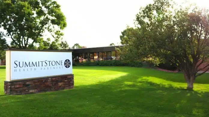 Front entrance of SummitStone Health Partners in Loveland, Colorado, showing accessible pathways and facility signage
