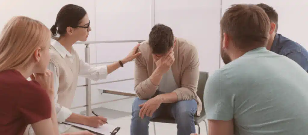 A group of people writing notes together around a table, planning an intervention - how to stage intervention A group of people writing notes together around a table, planning an intervention - how to stage intervention