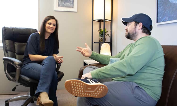 A therapist and client engaged in a one-on-one therapy session, looking empathetic - Christian rehab California A therapist and client engaged in a one-on-one therapy session, looking empathetic - Christian rehab California
