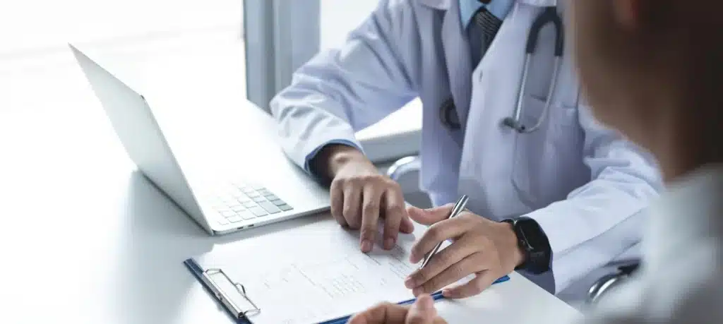 Person on phone call, relieved reviewing documents - Does Medicaid Cover Drug & Alcohol Rehab?