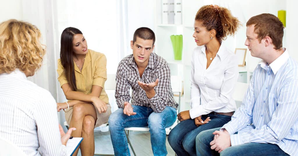 A group of people engaged in a supportive group therapy session - substance abuse treatment Scottsdale