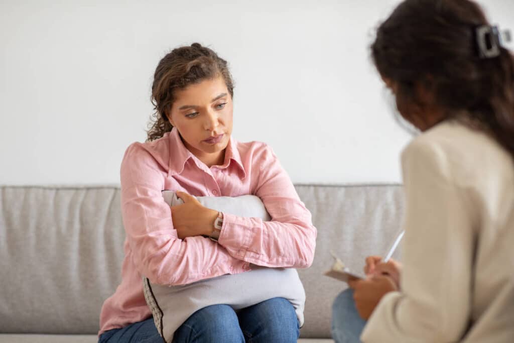 person looking distressed with a supportive hand on their shoulder - Mental health intervention