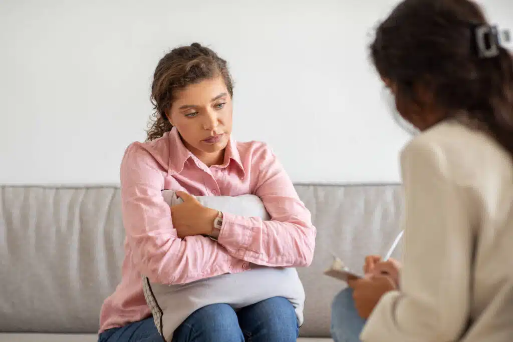 person looking distressed with a supportive hand on their shoulder - Mental health intervention person looking distressed with a supportive hand on their shoulder - Mental health intervention