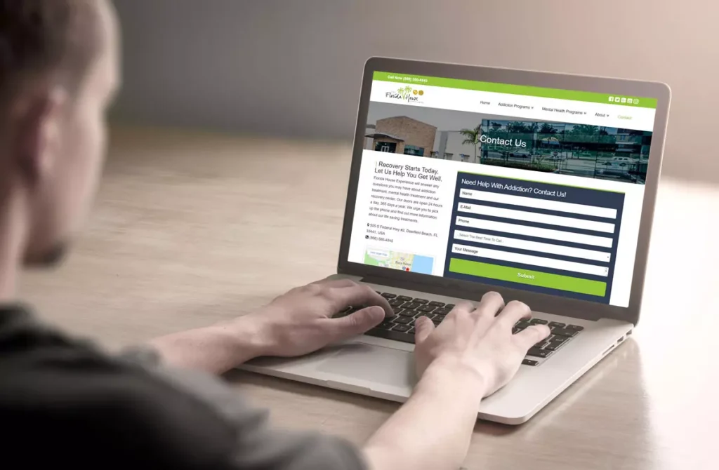 A person's hands typing on a laptop with a treatment search website on the screen - Find drug treatment
