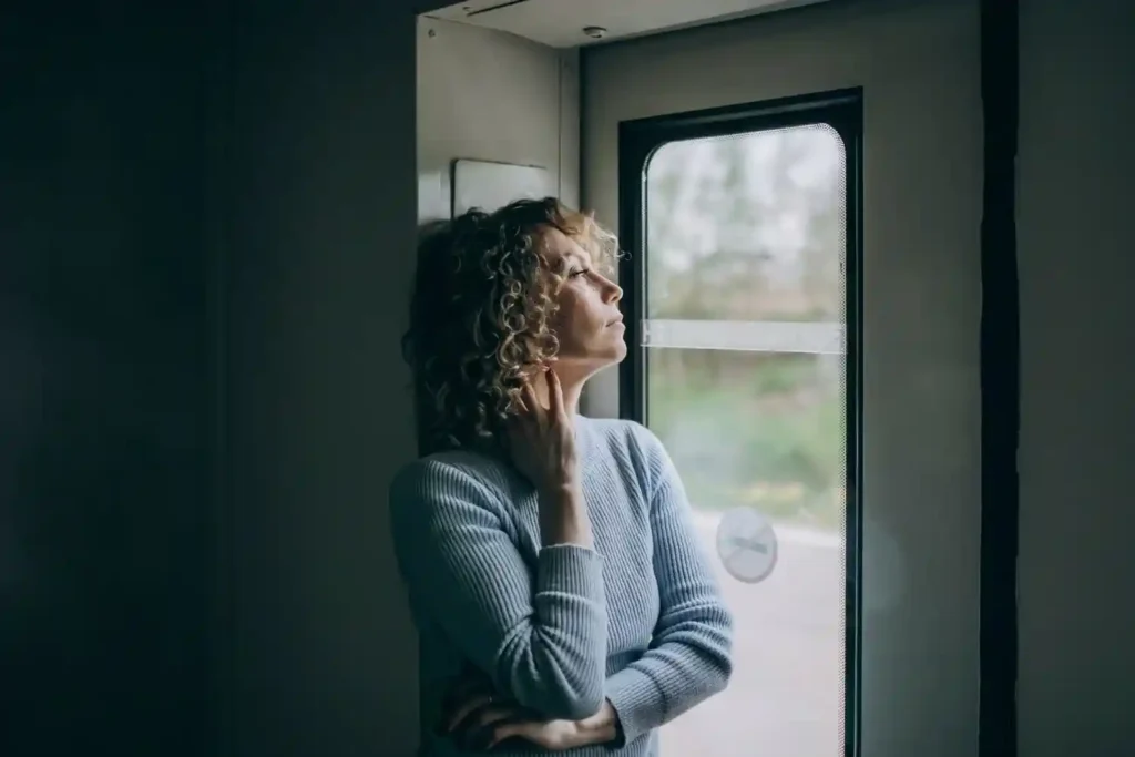 An anxious woman sitting alone, appearing stressed and overwhelmed while coping with anxiety and emotional struggles