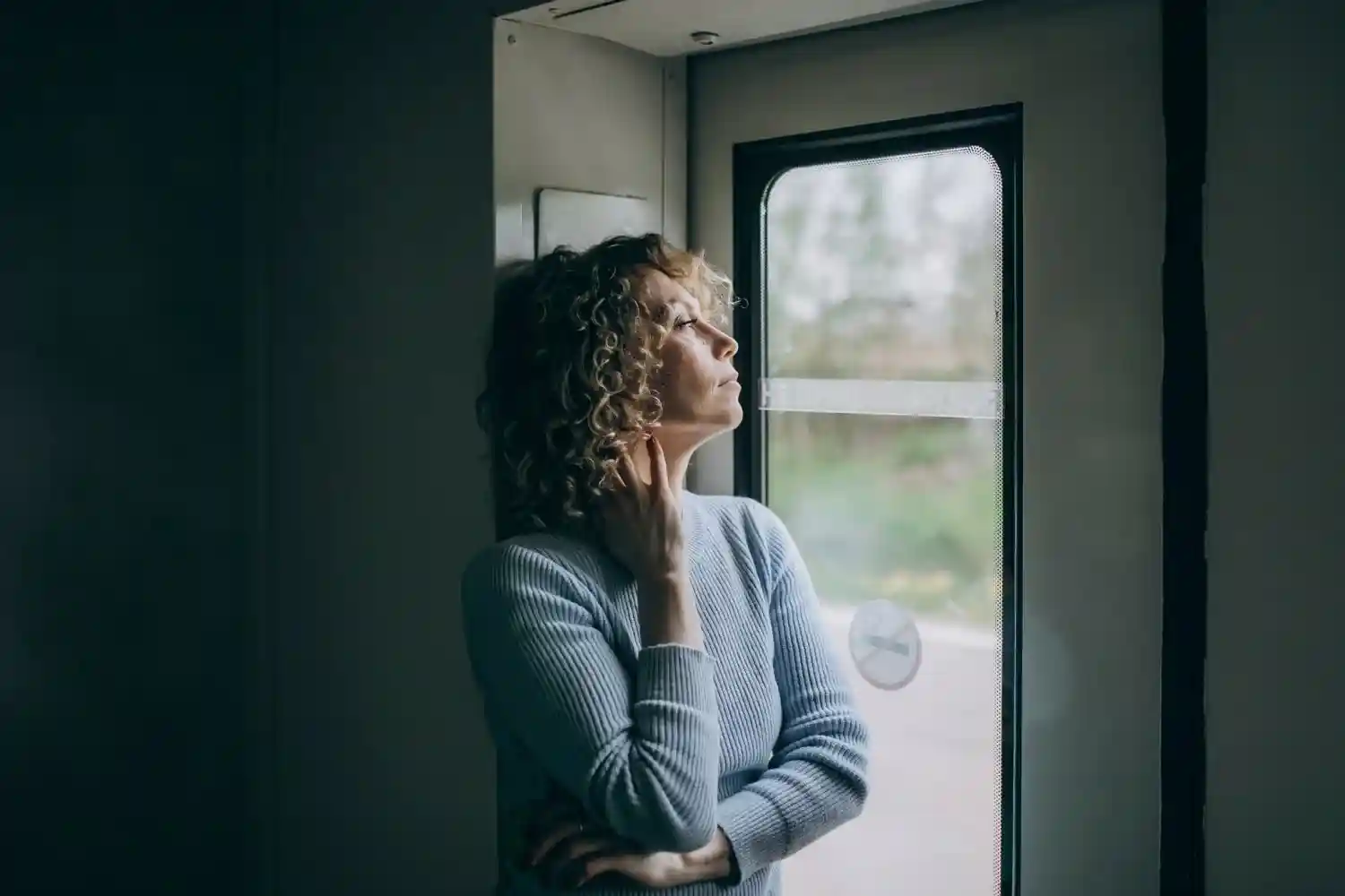 An anxious woman sitting alone, appearing stressed and overwhelmed while coping with anxiety and emotional struggles
