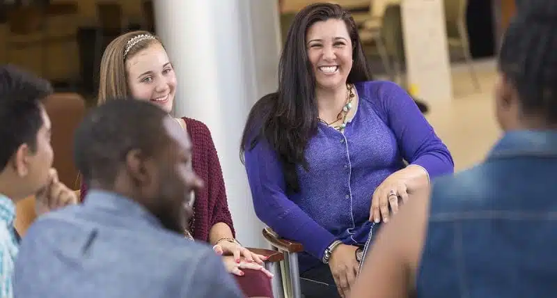 A diverse group of people engaged in a supportive group therapy session, smiling and interacting positively - aftercare for eating disorders A diverse group of people engaged in a supportive group therapy session, smiling and interacting positively - aftercare for eating disorders